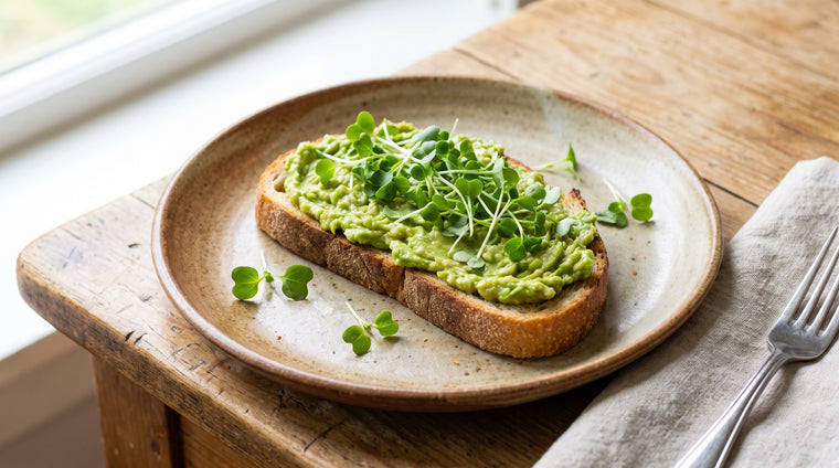 A handful of fresh broccoli microgreens over avocado toast.